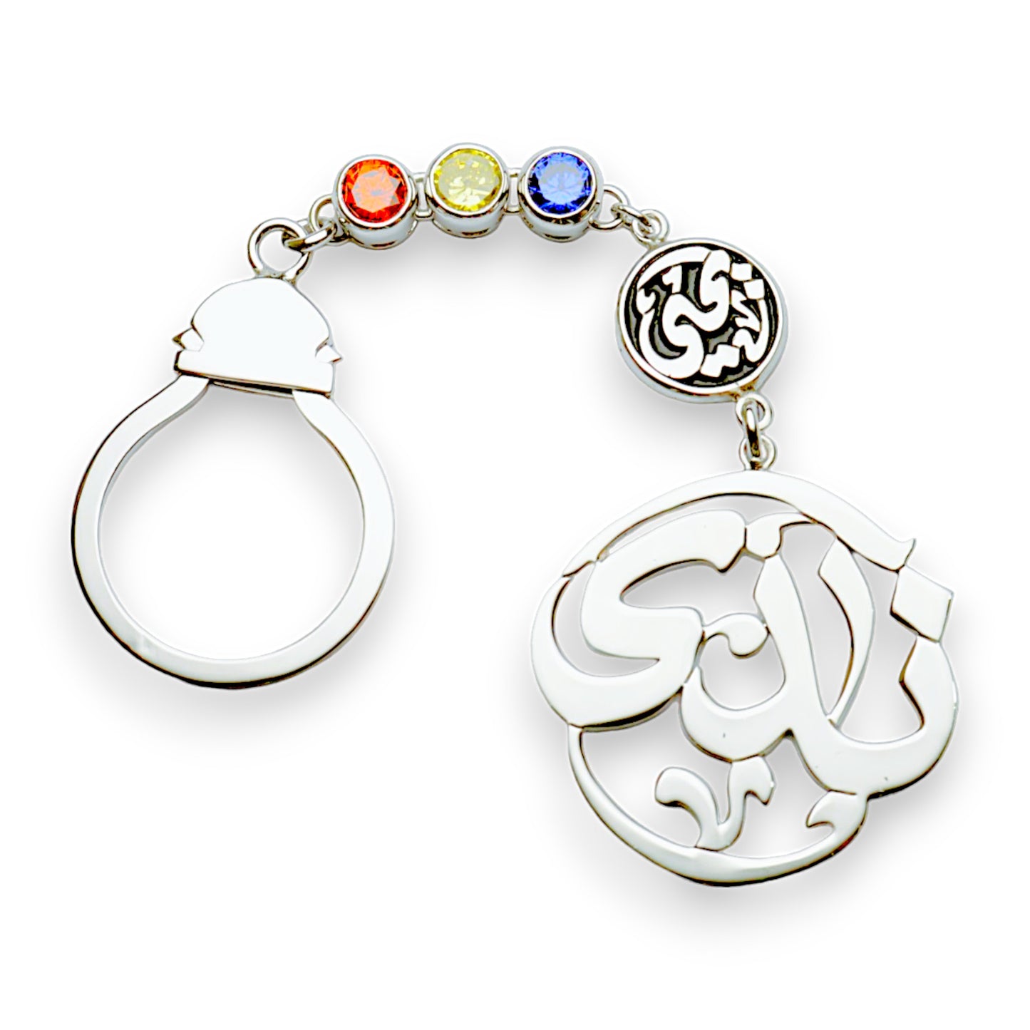 A silver keychain with a ring at the top, featuring multicolored birthstones and an Arabic calligraphy design in the center.