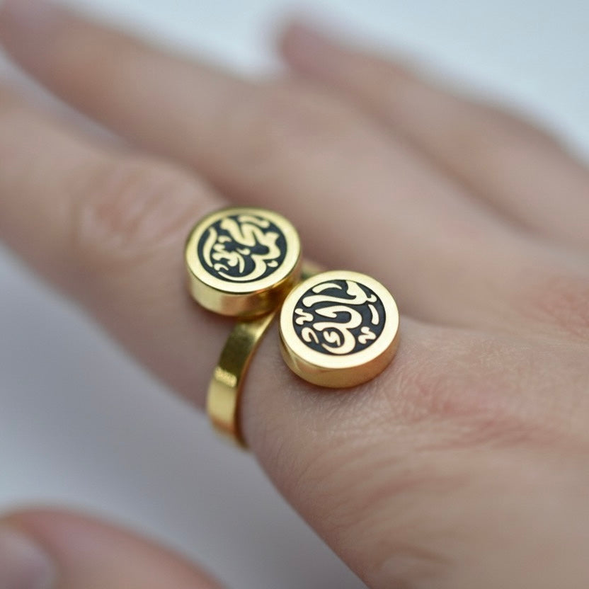 Gold rings with Arabic calligraphy on a hand