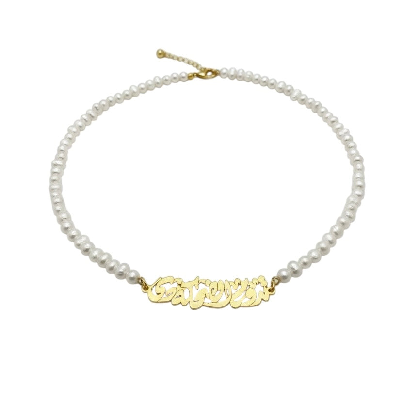 Pearl necklace with a gold nameplate on a white background