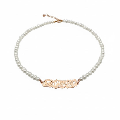 Pearl necklace with a gold nameplate on a white background