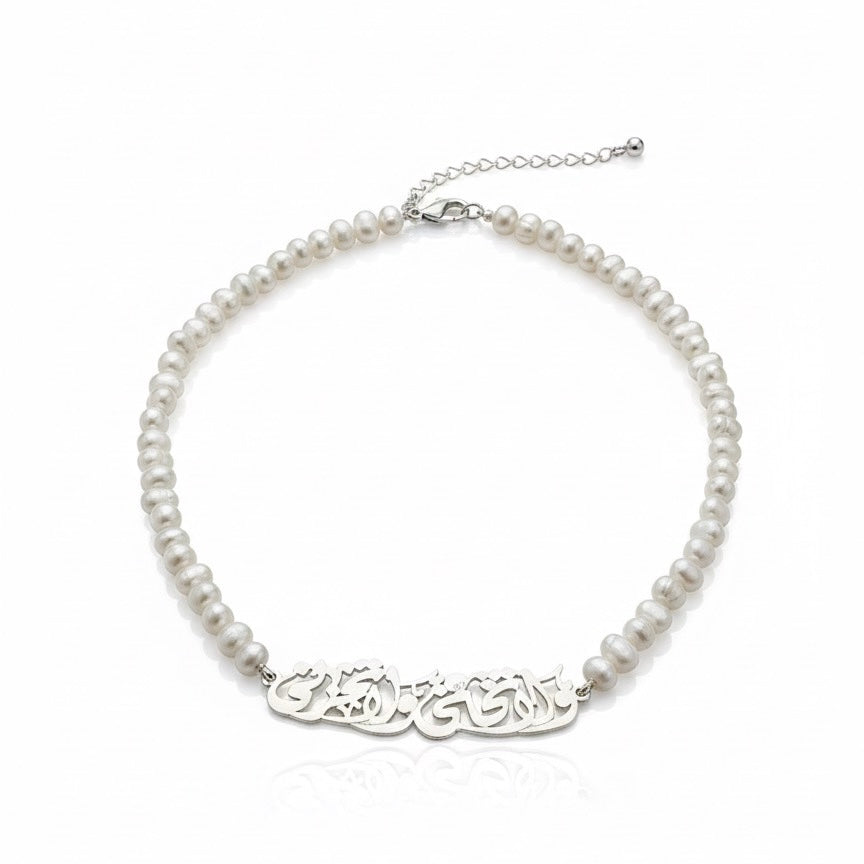 Pearl necklace with a silver nameplate on a white background